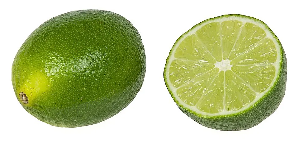 A whole lime beside a halved lime